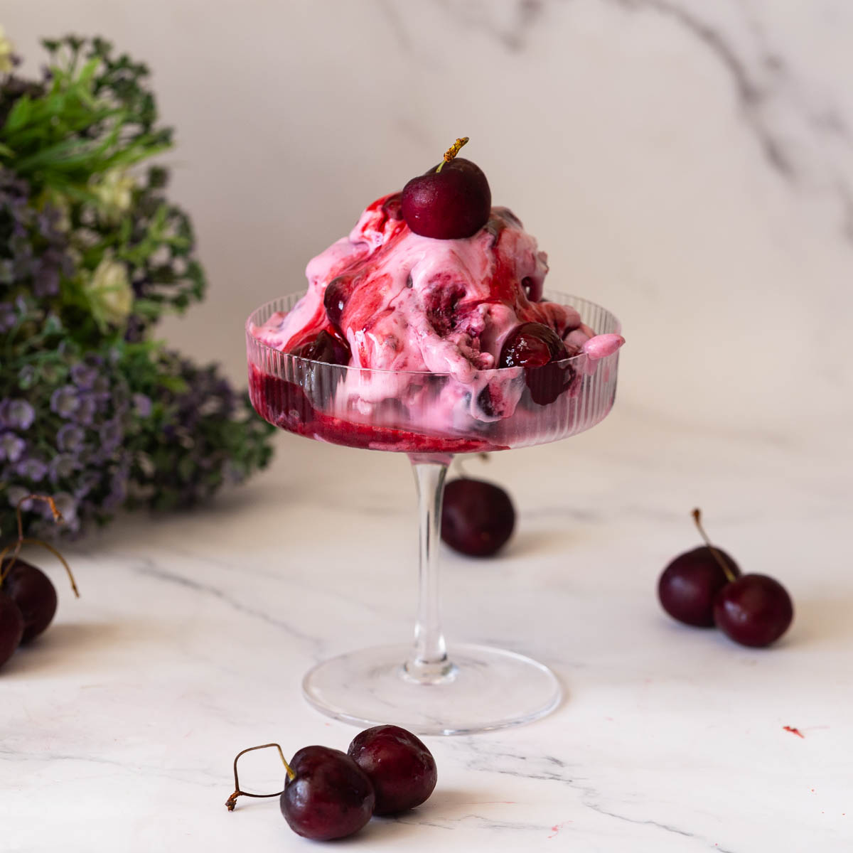 A glass glass with cherry ice cream with filling.