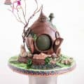 A decorated cake in the shape of a hobbit house.