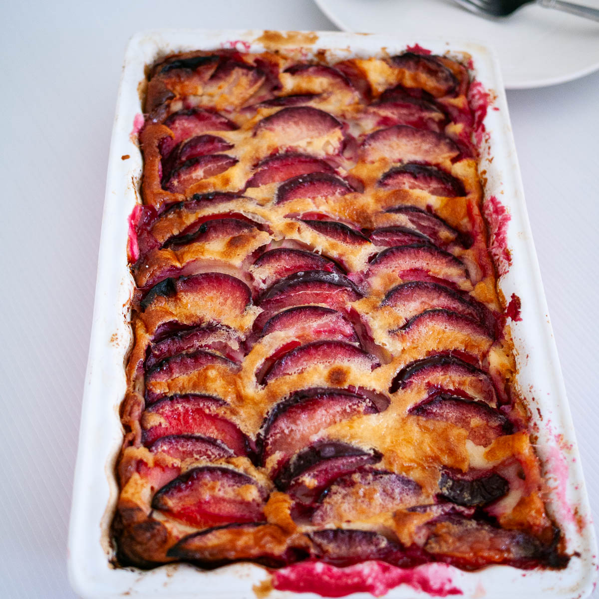 A baking dish with fresh baked plum clafoutis.