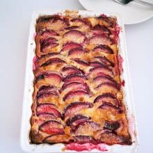 A baking dish with baked clafoutis with plums.