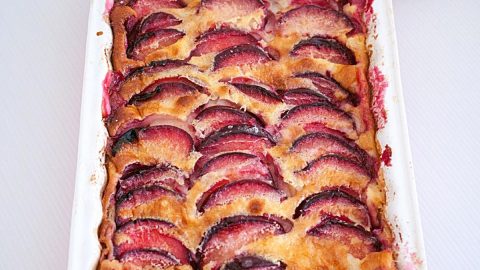 A baking dish with baked clafoutis with plums.