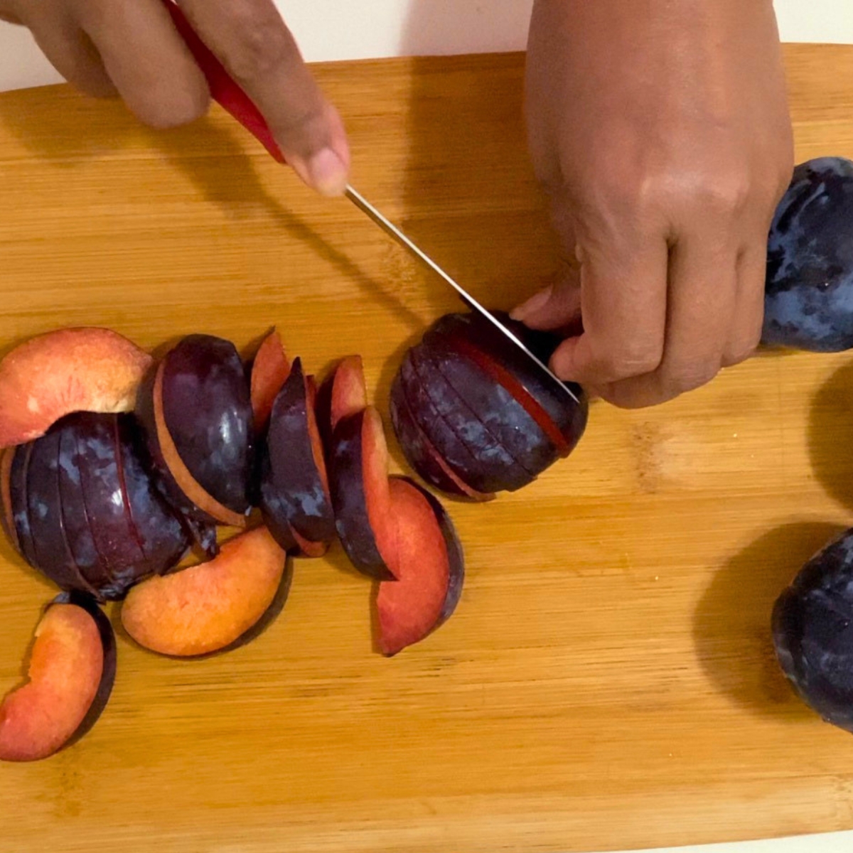 Slicing fresh plums for clafoutis.
