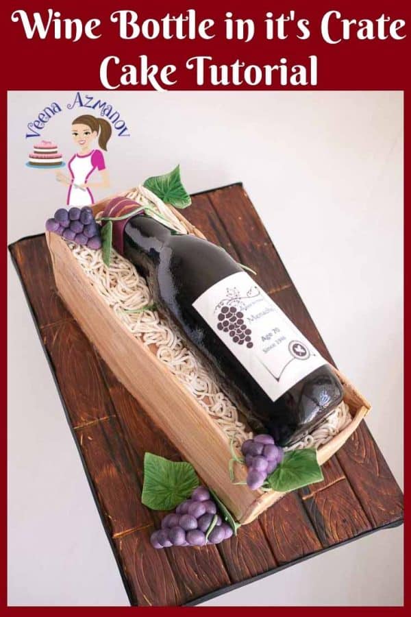 A decorated cake shaped like a wine bottle in a wooden box.