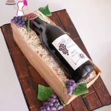 Novelty cake wine bottle and crate on a cake board.