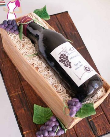 Novelty cake wine bottle and crate on a cake board.