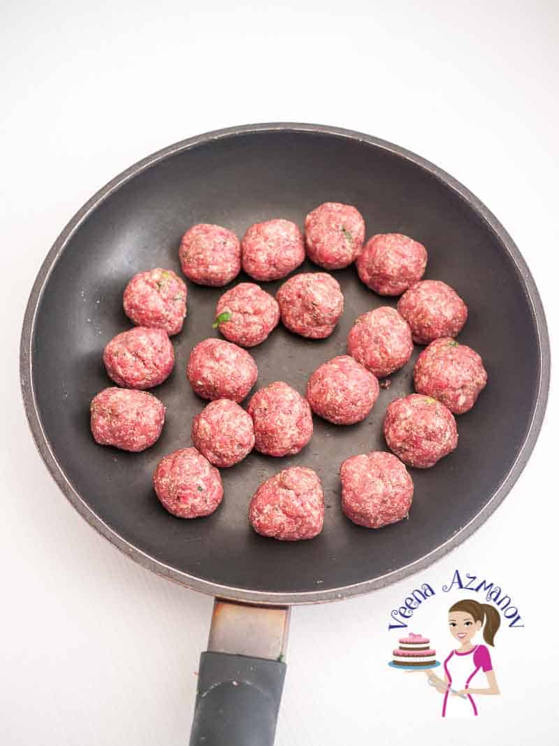 A pan with raw meatballs.