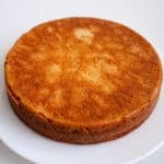 A vanilla cake on a cake stand.