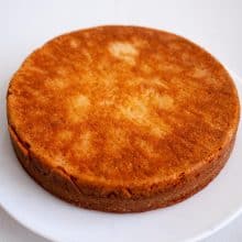 A vanilla cake eggless on a cake stand.