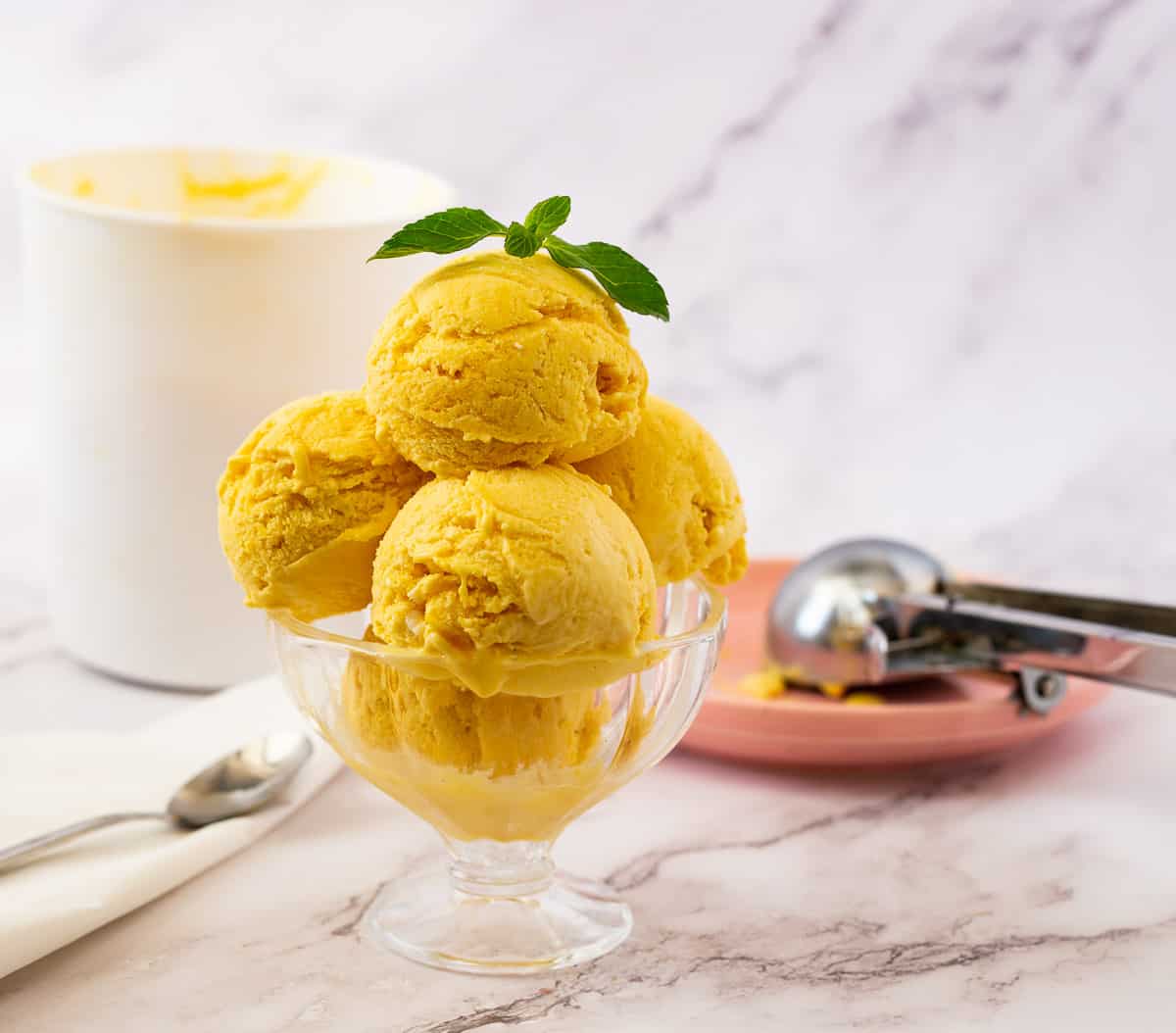 Scoops of mango ice cream in a bowl.