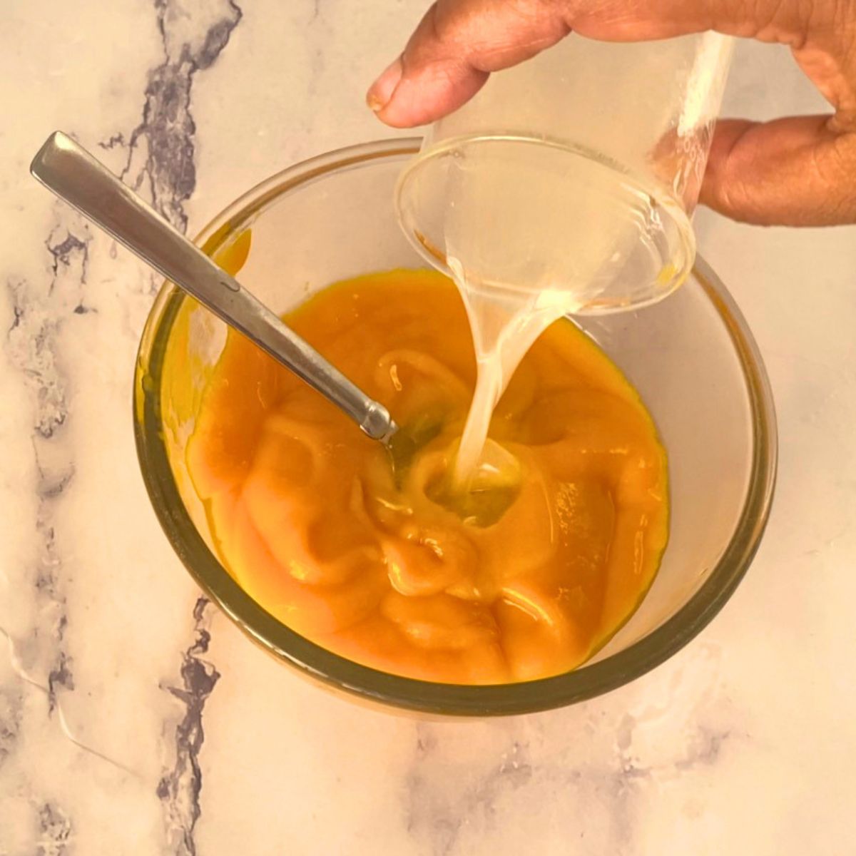 Adding gelatin to the mango topping for mousse.