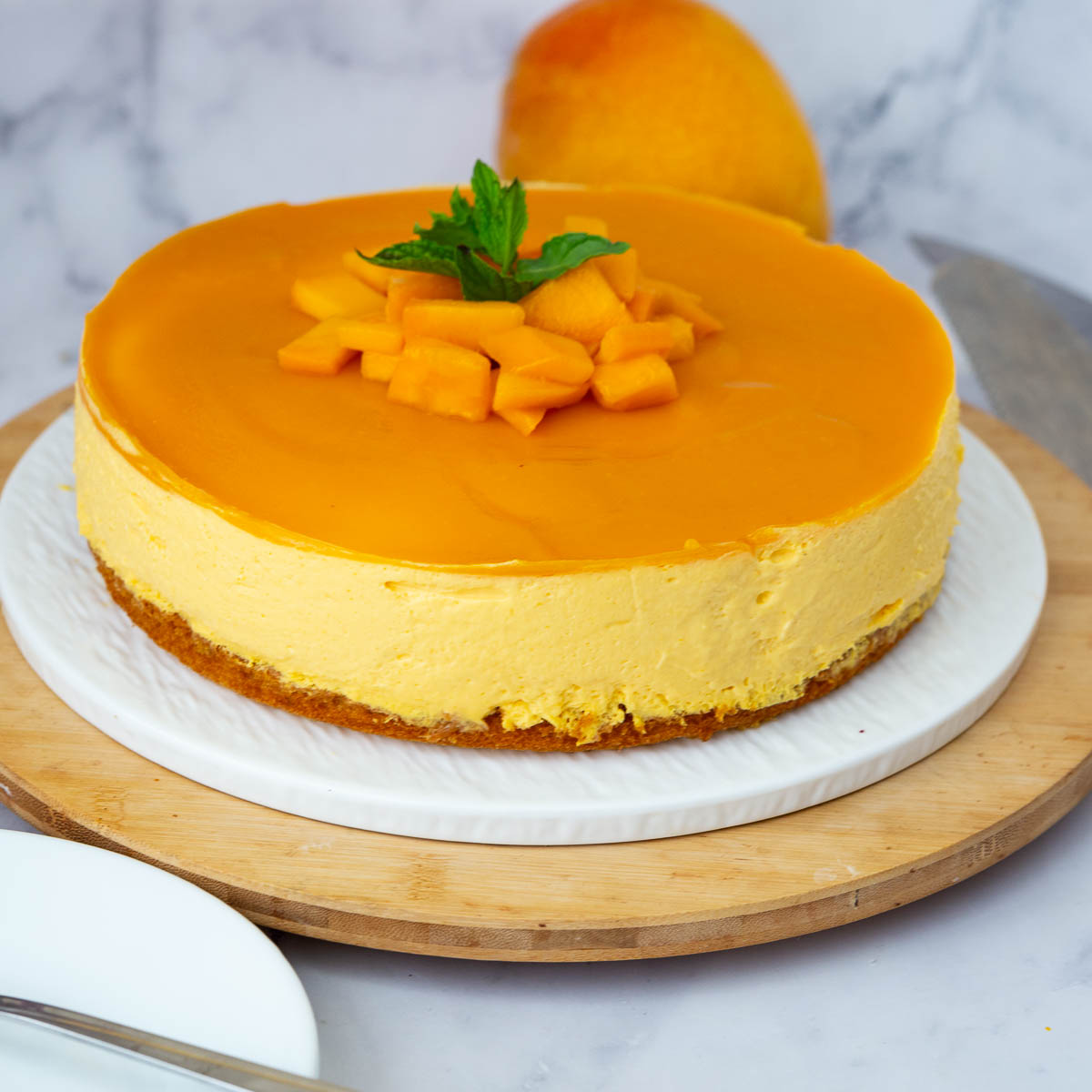 A mango mousse cake on the cake stand.