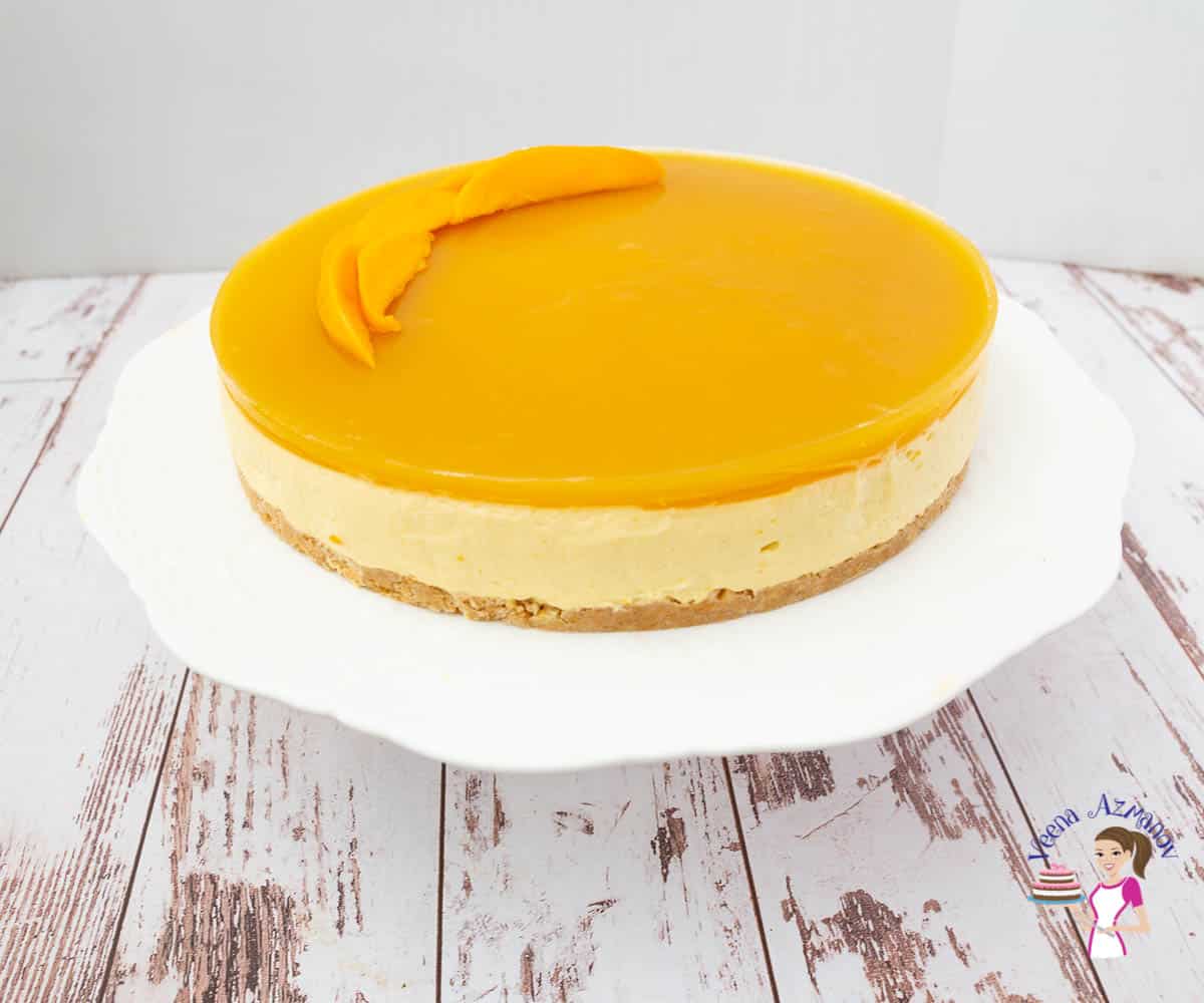 A mango mousse cake on a stand.