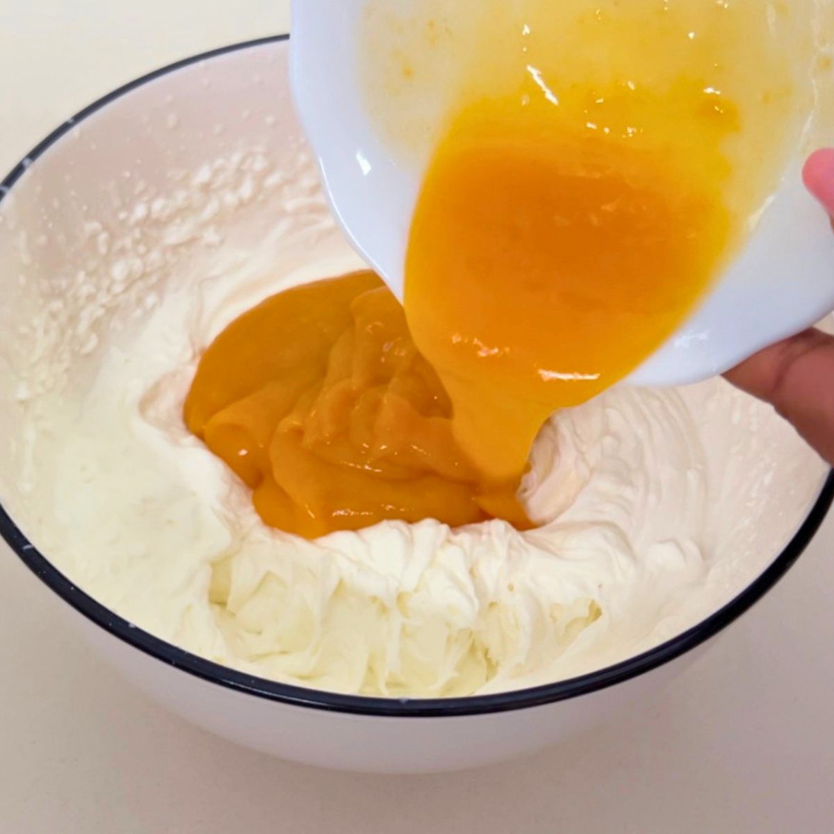 Adding gelatin to the mango mousse.