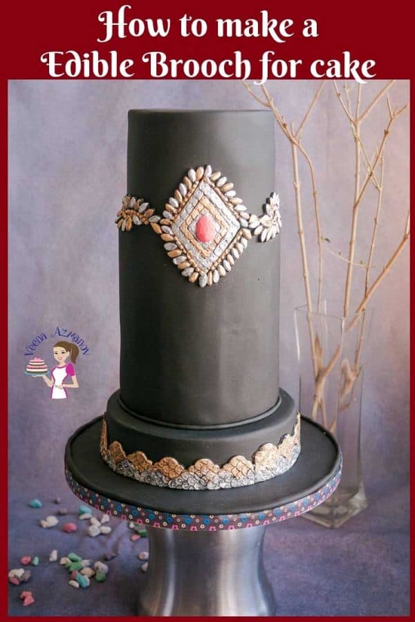 A brooch decorated black fondant cake.