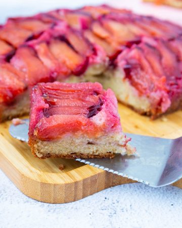 A slice of plum cake on a wooden boards.