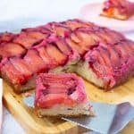A cake with fresh plum on the table.