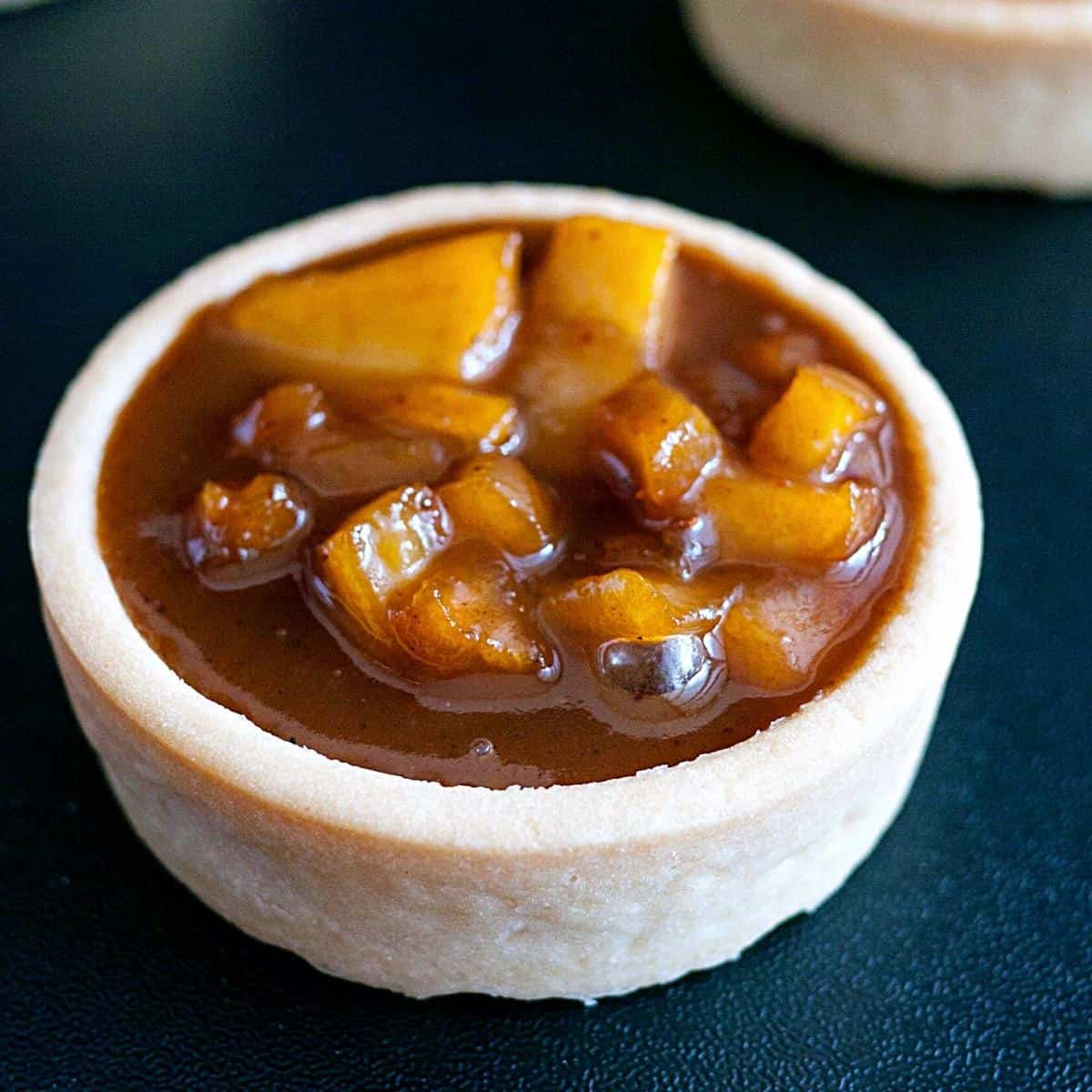 Mini tart shell filled with caramel apple filling.