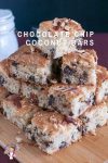 A stack of chocolate chip cake squares on a board.