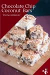 A stack of chocolate chip cake squares on a board.