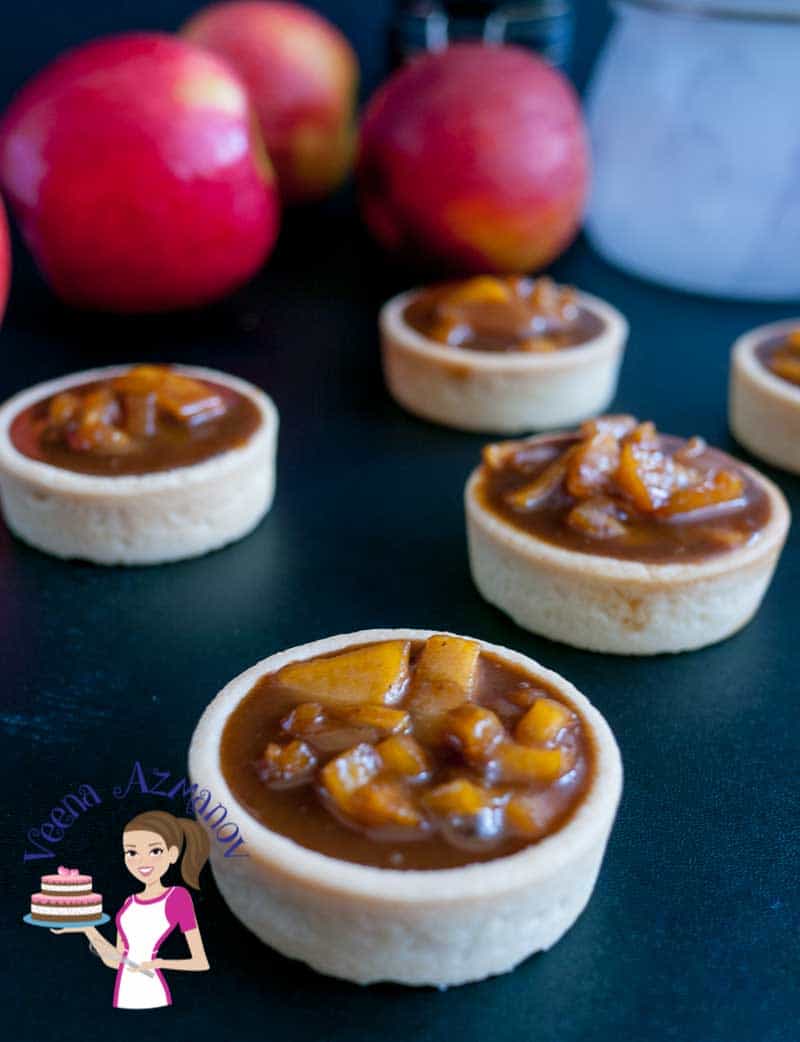 Front angle of the tarts- Rich, creamy, fruity and caramelized these exotic cinnamon caramel apple tarts are an absolute treat. Filled in crisp short crust pastry baked to perfection. These are perfect fir fall or any time of the year mini desserts and make entertaining a breeze.