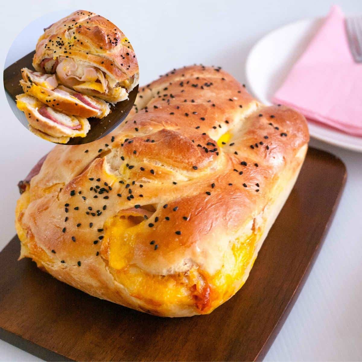A ham and cheese stuffed bread on a board.
