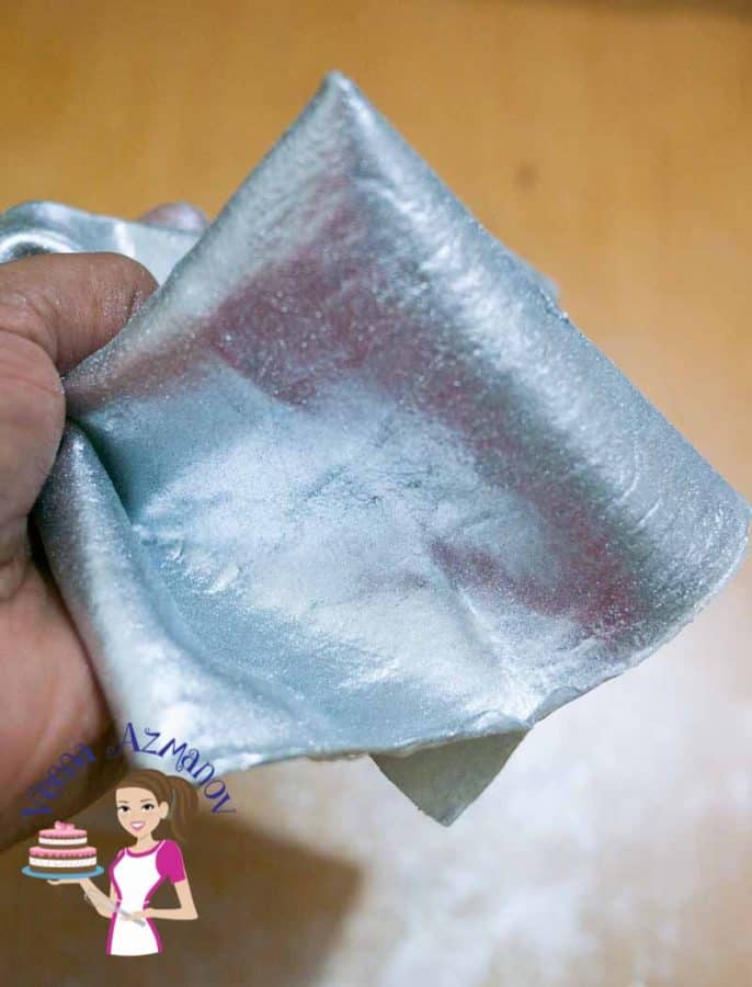 A person holding edible fabric for cake decorating.