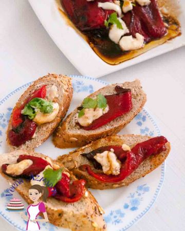 A plate with roasted red pepper and goat cheese crostini.