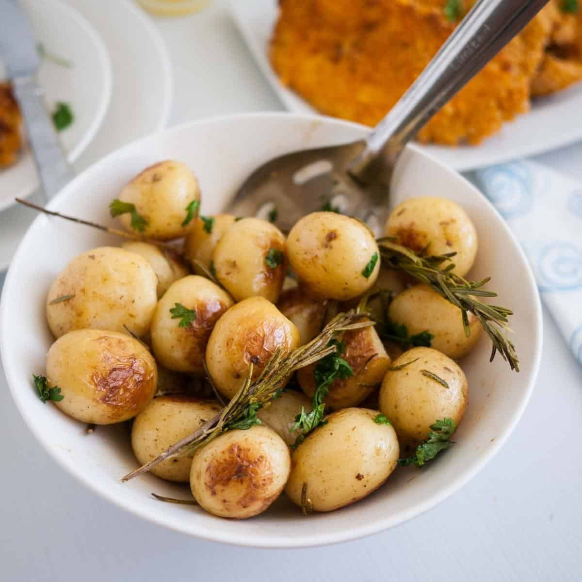 a white bowl with rosemary potatoes