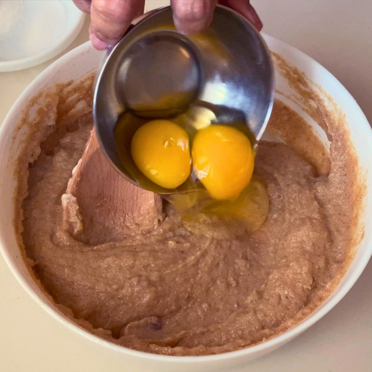 Adding egg and egg yolk to the cookie dough.