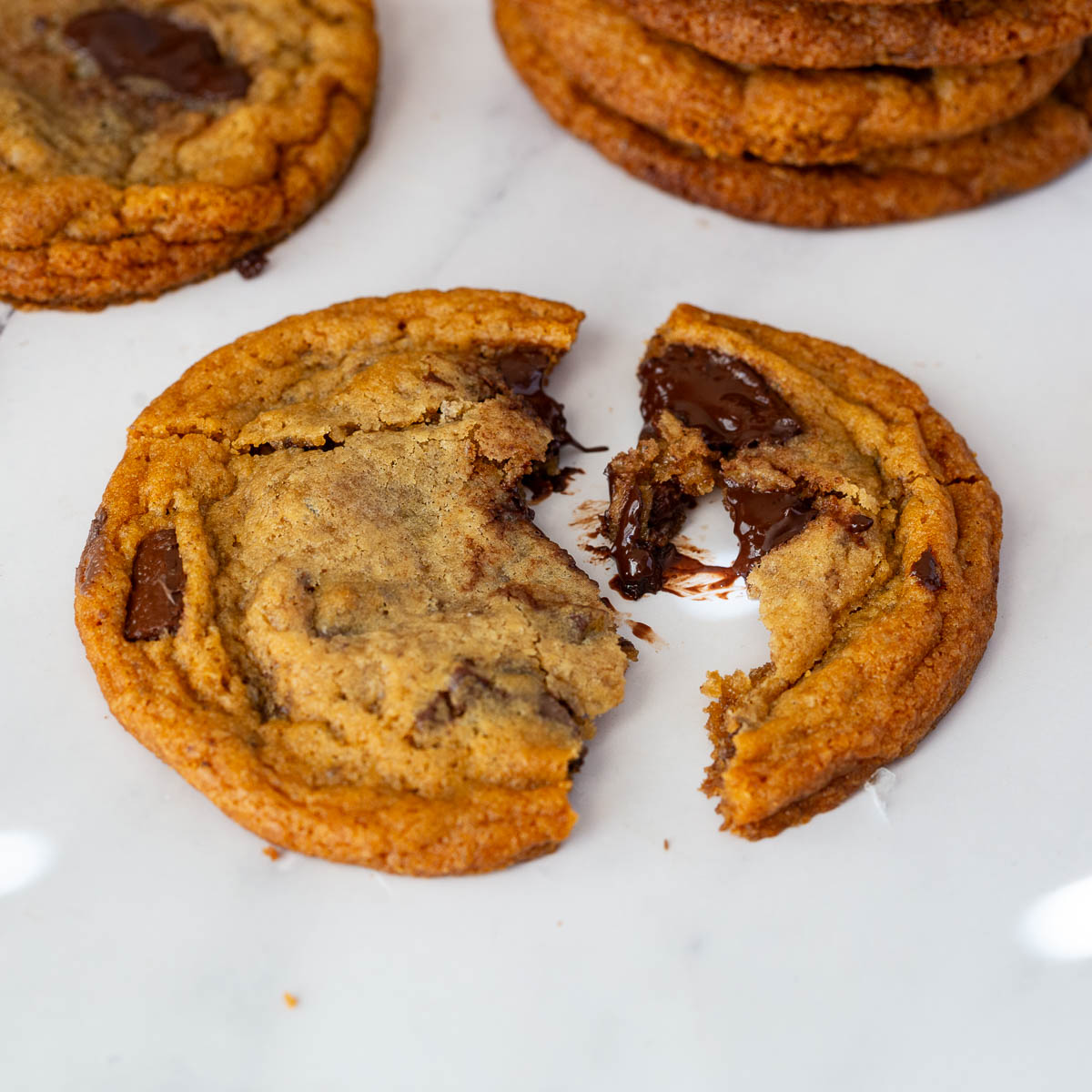A broken chocolate chip cookie on the table.