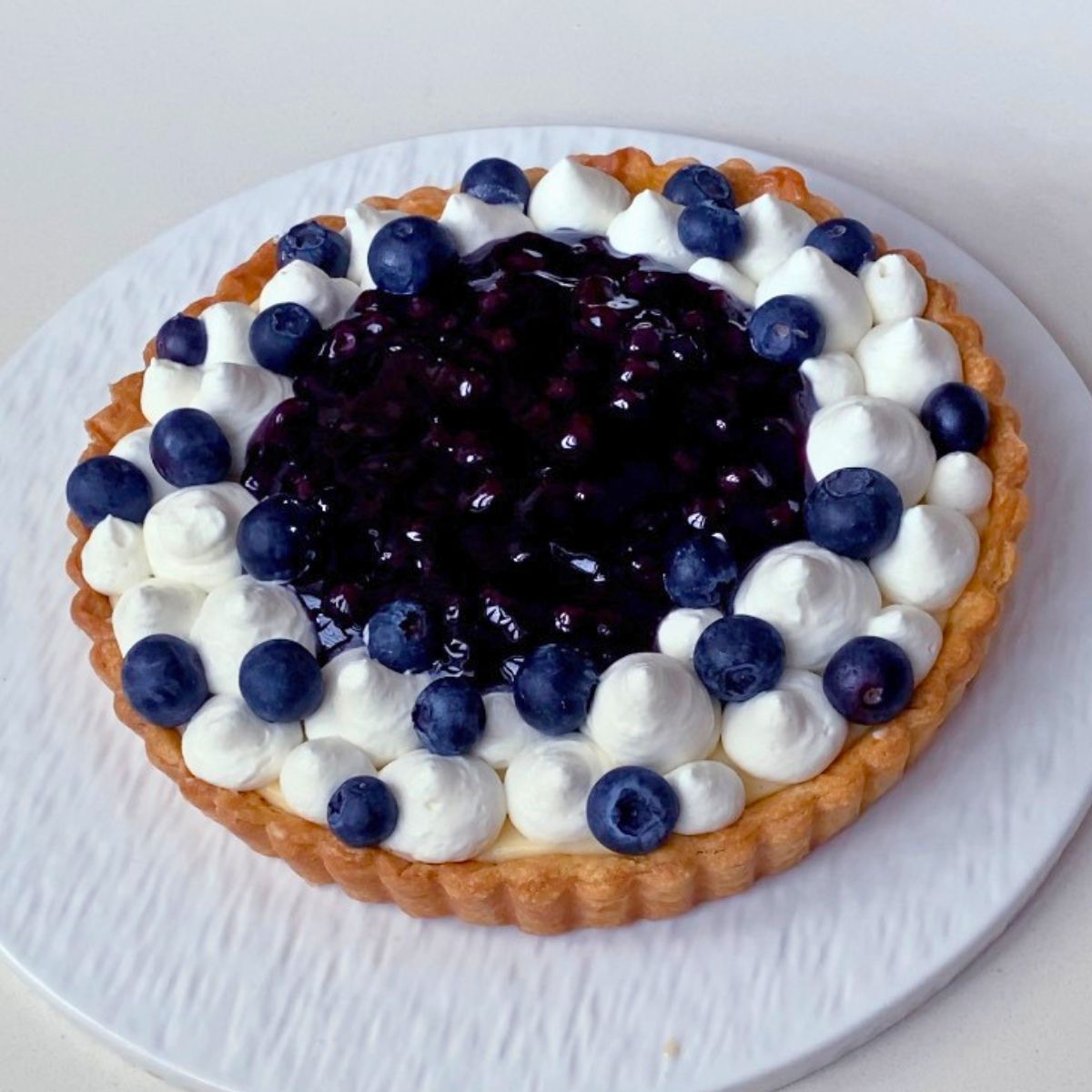 Adding fresh blueberries to the tart.