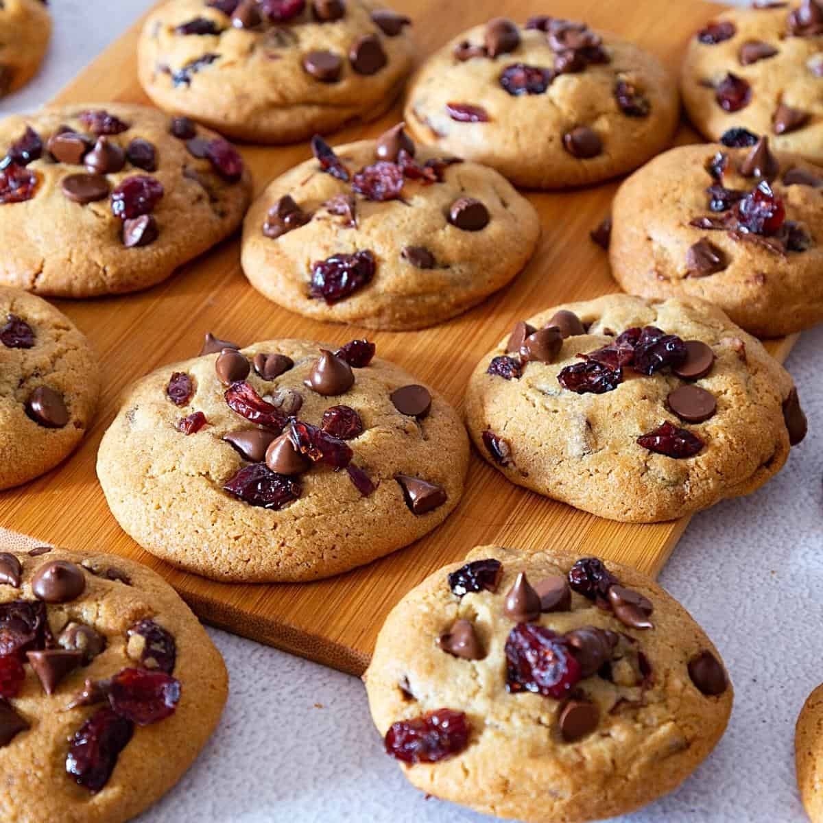 Cranberry cookies with chocolate chips on a wooden board.