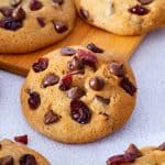 A cook with chocolate and cranberries on a table.