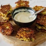 Latkes on a wooden board with yogurt dip.