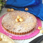 Baked tart with macadamia nuts on the table.