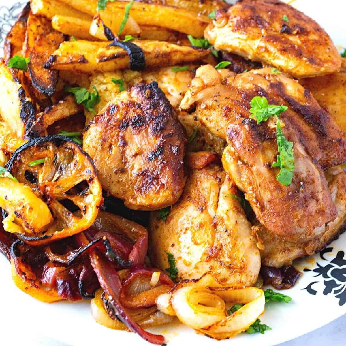 A plate with sheet pan chicken and potatoes.