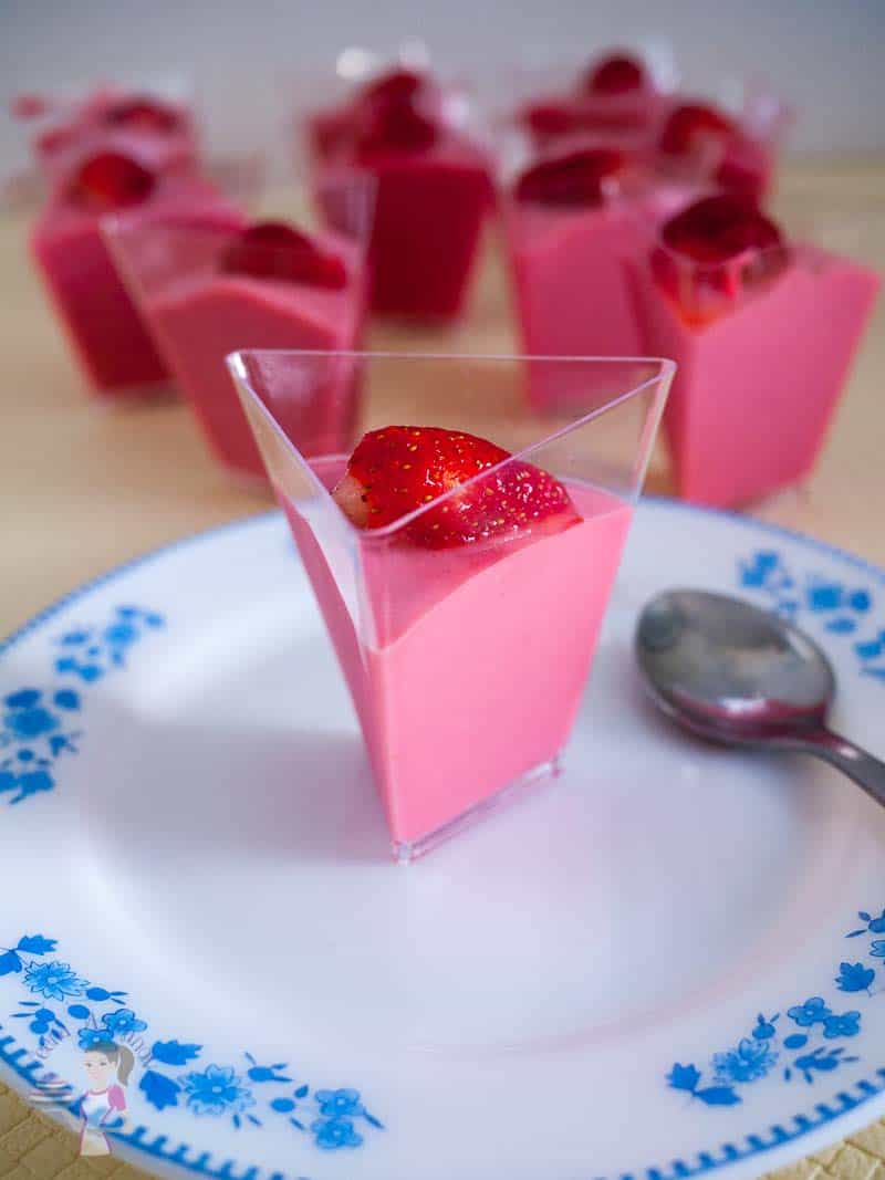 A prism shaped glass of strawberry mousse.
