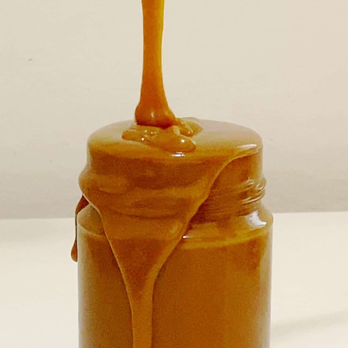 Pouring caramel in a mason jar.