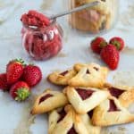 A stack of Purim cookies with strawberry filling.