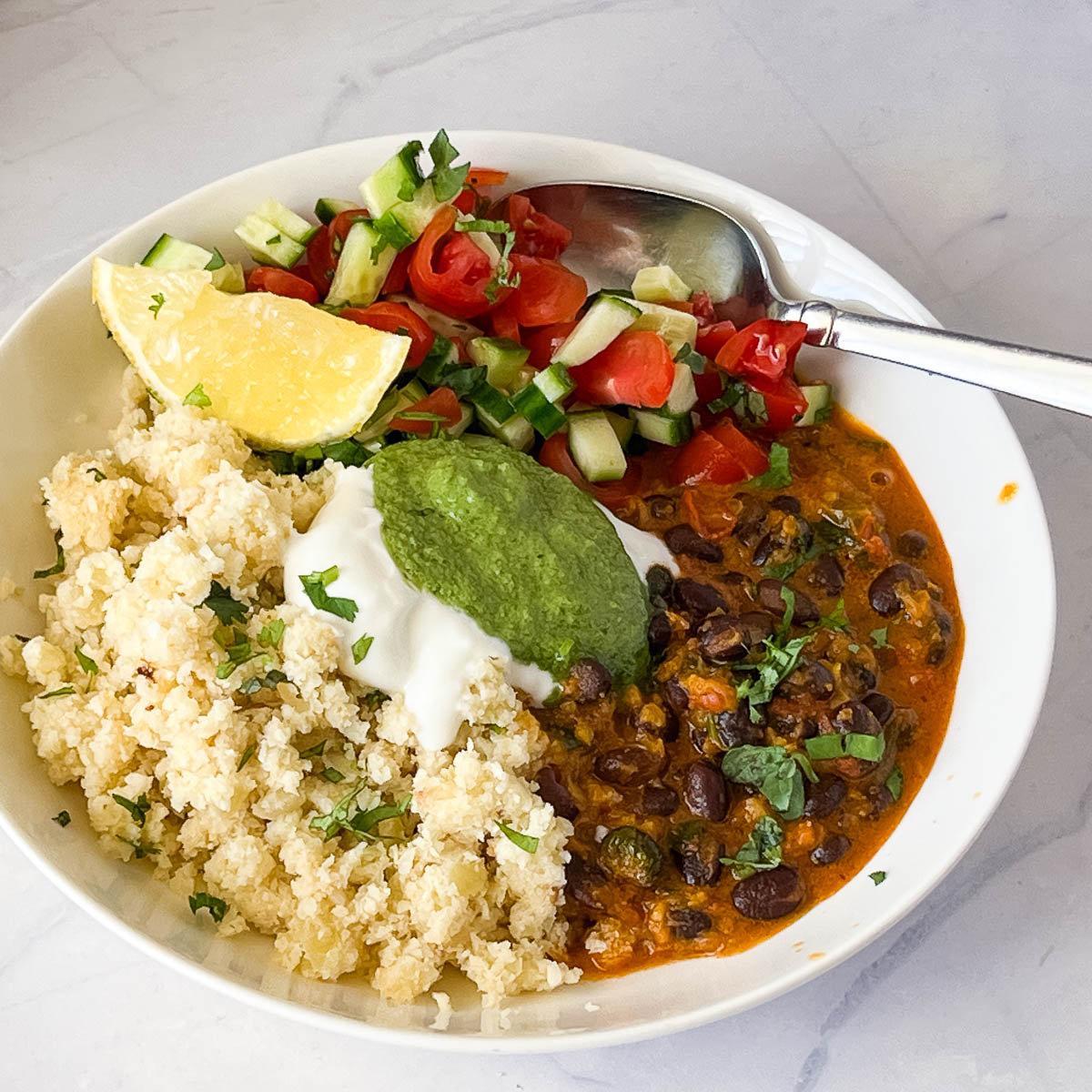 A white plate with cauliflower rice and kidney beans.