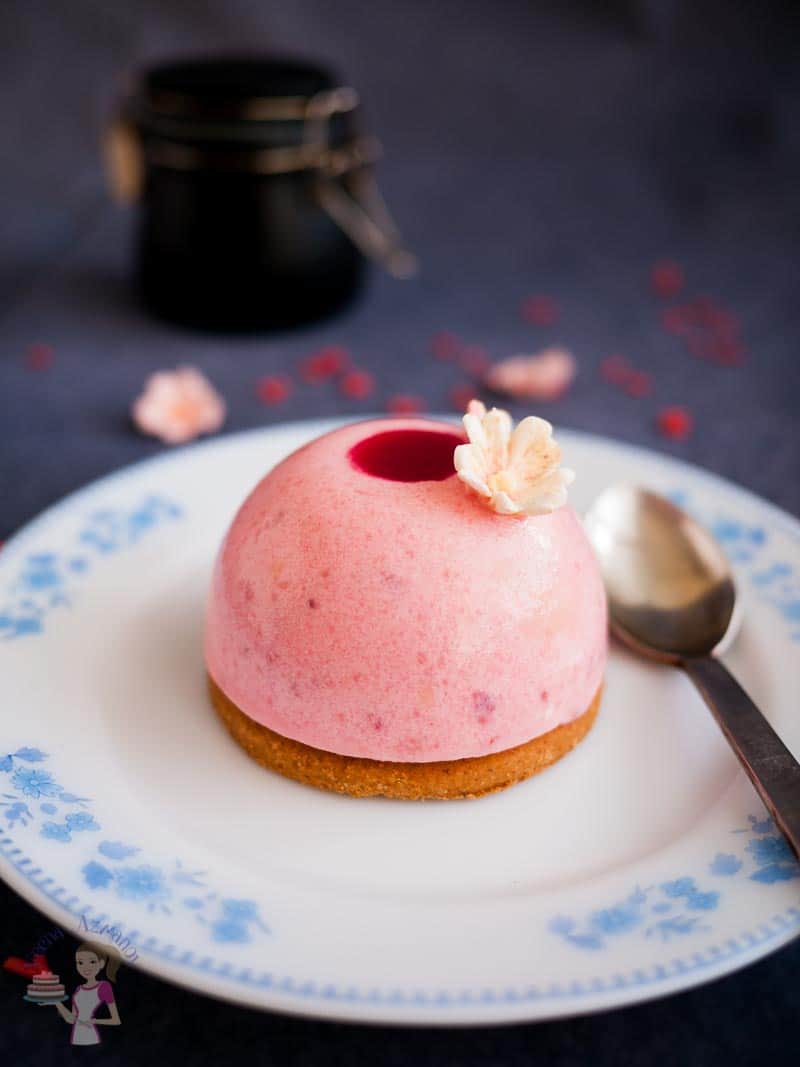 A strawberry mousse dome on a plate.