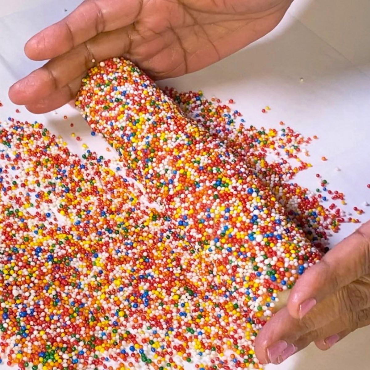 Rolling the sugar cookie log in sprinkles.