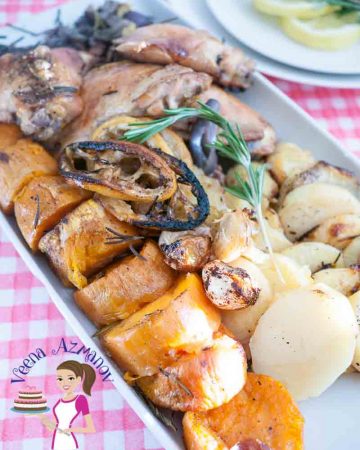 A tray with sheet pan chicken and baked vegetables.
