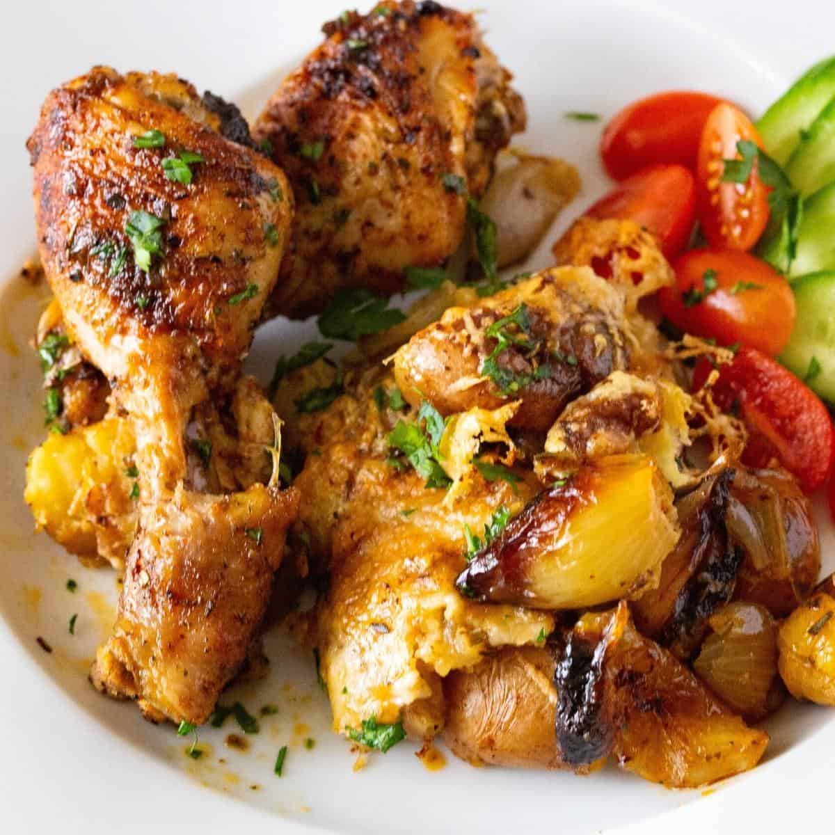 Roasted chicken on a. plate with smashed potatoes.