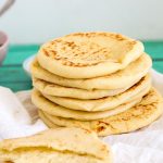 A stack of pita bread on a table.