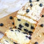 A sliced loaf cake with blueberries and crumble.