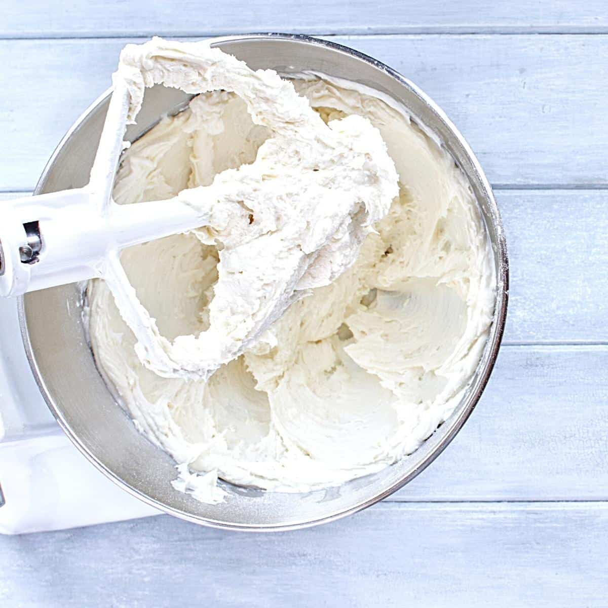 A stand mixer bowl with cream cheese frosting.