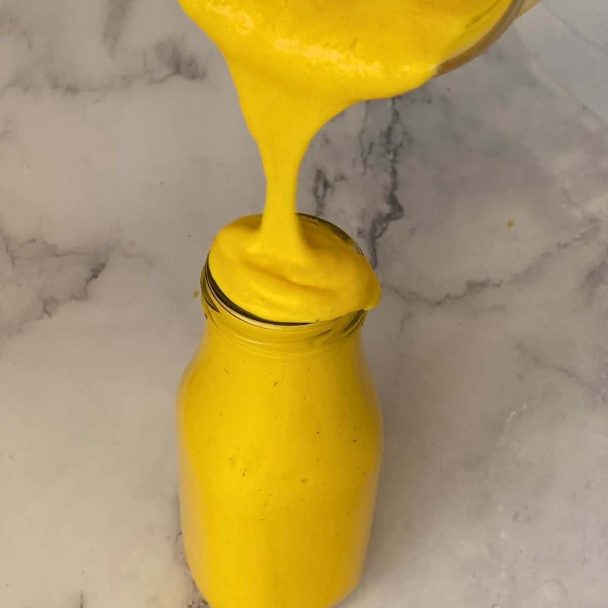 Pouring smoothie into the milk bottle glass.