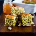 3 squares of baklava on a wooden tray.
