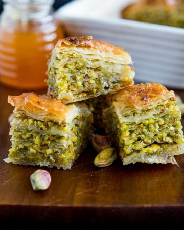 3 squares of baklava on a wooden tray.